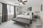 Master bedroom with king bed, lounge space, dual nightstands and lamps , ceiling fan